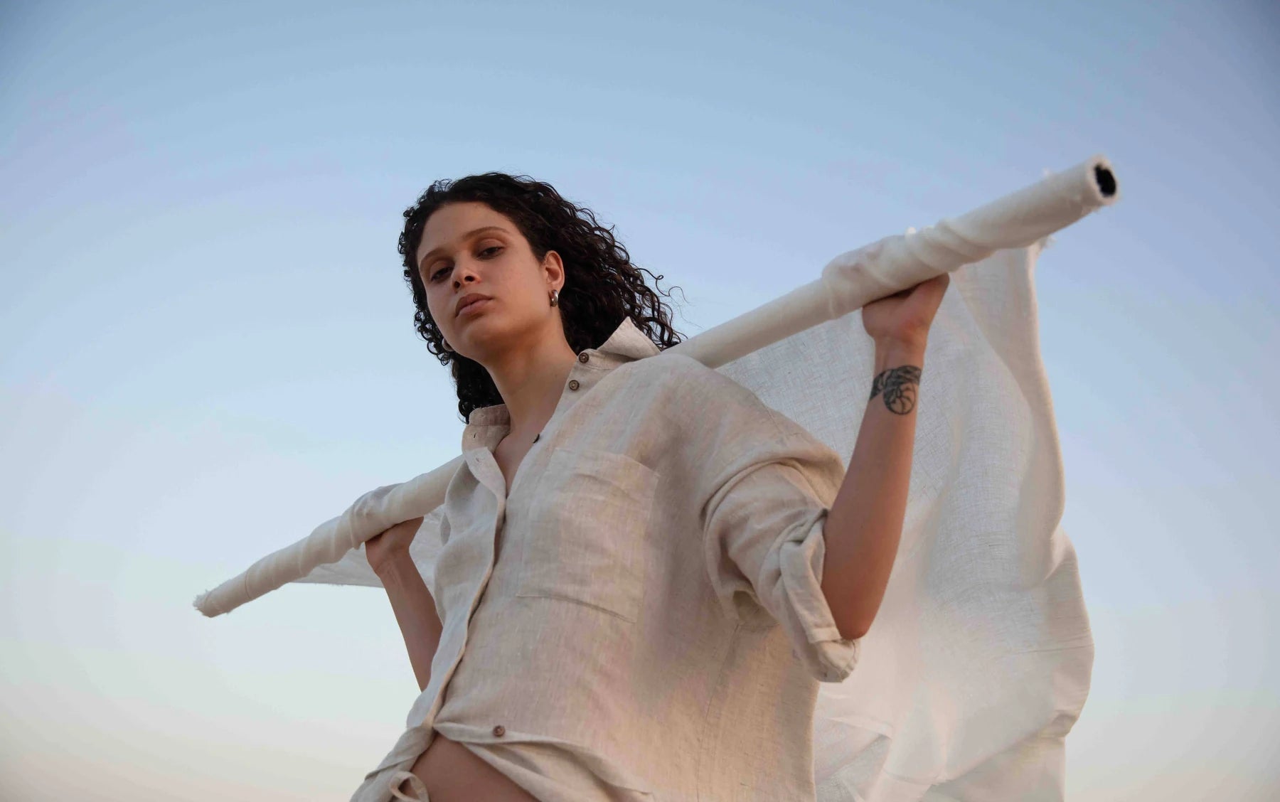 Woman moving a linen scarf in the breeze